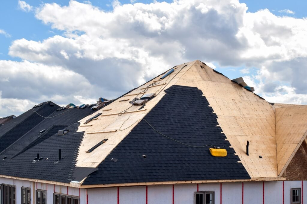 The process of installation of black roof shingles on new residential home