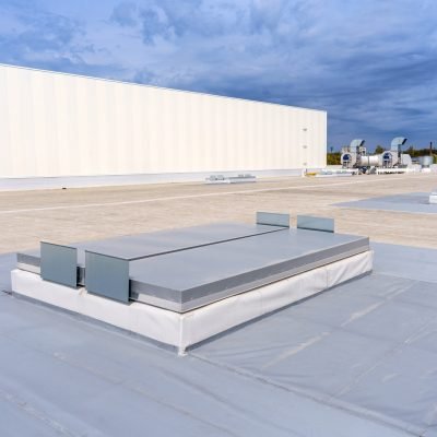 White metal sheet rooftop wall on commercial building with blue sky